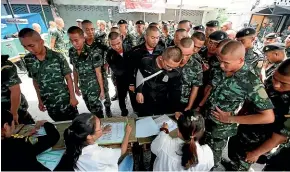  ?? AP ?? Soldiers line up for voting in general election at a polling station in Bangkok, Thailand.