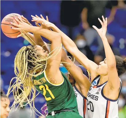  ?? ELSA/GETTY IMAGES ?? Baylor’s DiJonai Carrington puts up a shot as UConn’s Aaliyah Edwards and Olivia Nelson-Ododa, right, defend late in the River Walk Region Final of the NCAA Women’s Tournament on Monday night.