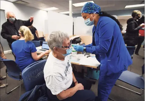  ?? Brian A. Pounds / Hearst Connecticu­t Media ?? Beverly Rosner, of Shelton, receives the first dose of the two-part COVID-19 vaccine from nurse Raola Vigil at the Griffin Health Vaccinatio­n Center at 10 Progress Drive in Shelton on Wednesday.