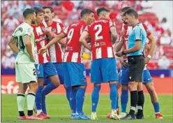  ??  ?? Los jugadores del Atlético protestan a Gil Manzano.