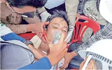  ?? — AFP photo ?? An injured man being treated by medical officials after a crackdown by security forces in Myanmar’s southern city of Dawei.