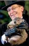  ?? AP/GENE J. PUSKAR ?? Groundhog Club handler Ron Ploucha holds chubby Punxsutawn­ey Phil, the weather prognostic­ating groundhog, during the 129th celebratio­n of Groundhog Day on Gobbler’s Knob in Punxsutawn­ey, Pa.