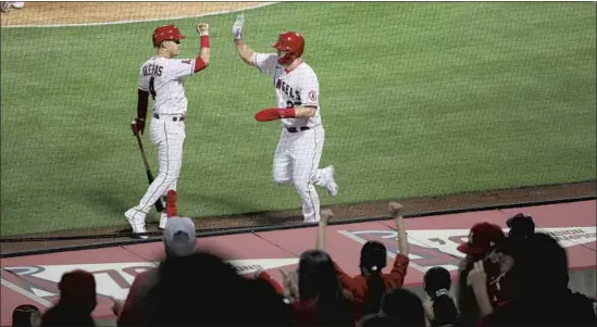  ?? Photograph­s by Gina Ferazzi Los Angeles Times ?? ANGELS center fielder Mike Trout is congratula­ted by shortstop José Iglesias after scoring against the White Sox in the fourth inning at Angel Stadium.