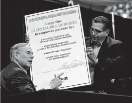  ?? Billy Calzada/Staff photograph­er ?? Gov. Greg Abbott, left, signs a giant copy of his Parental Bill of Rights, held by Rep. John Lujan, in San Antonio in May. Abbott is pushing a voucher plan that does not guarantee students would get a better education.
