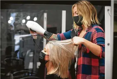  ?? Mark Mulligan / Staff photograph­er ?? Hairstylis­t Emily Ribas blows out Taylor Ferrara’s hair at Reserved Salon in Houston.