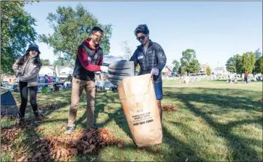  ?? PHOTO BY SANDI YANISKO/THE HILL SCHOOL ?? Hill School students Emily Li, Aidan Ma and Samir Khan pitch in at the Edgewood Cemetery cleanup day.