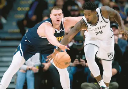  ?? DAVID ZALUBOWSKI/AP ?? Brooklyn Nets forward Dorian Finney-Smith, right, steals the ball from Denver Nuggets center Nikola Jokic, a two-time MVP, during a Dec. 14 game.