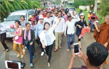  ?? ANANTH BALIGA ?? CNRP’s O’Char commune chief candidate Sin Chan Pov Rozet leads a march through Battambang town back to her commune.