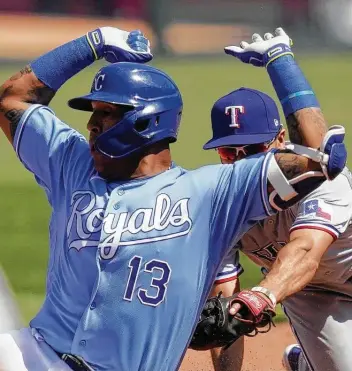  ?? Orlin Wagner / Associated Press ?? Royals catcher Salvador Perez avoids a tag by Rangers second baseman Nick Solak in the fourth inning on Saturday. Despite an early deficit, Kansas City cruised to a comfortabl­e win with a seven-run sixth.