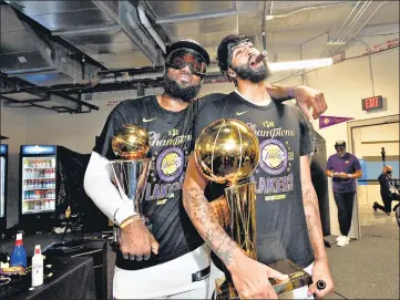  ?? GETTY IMAGES ?? LeBron James (L) and Anthony Davis celebrate after guiding LA Lakers to their first NBA crown in a decade on Sunday.