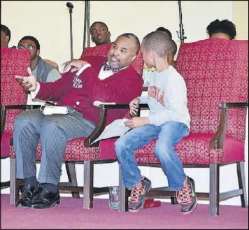  ?? CONTRIBUTE­D ?? The Rev. Charles L. Fischer III confers with his son Charles IV during a college day program at Providence Missionary Baptist Church.