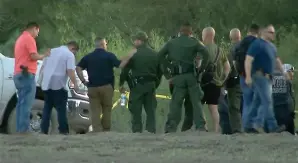  ?? (KRGV via AP) ?? In this frame grab taken from video provided by KRGV, authoritie­s gather near where a helicopter flying over the U.s.-mexico border in Texas crashed, killing two National Guard soldiers and a Border Patrol agent Friday.