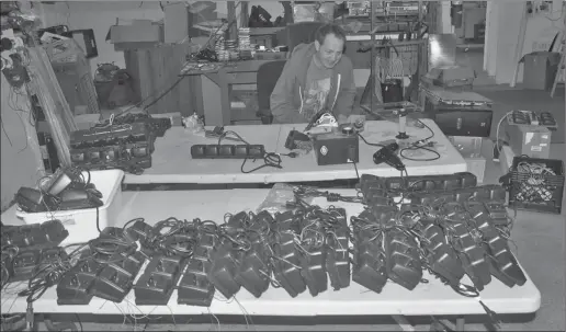  ?? Photos by Matthew Liebenberg ?? Lloyd Fehr looks at a table full of charging bases for two-way radios that will be used during the Western Canada Summer Games.