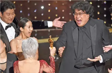  ?? CHRIS PIZZELLO INVISION/THE ASSOCIATED PRESS ?? “Parasite” director Bong Joon-ho celebrates as he accepts the Oscar for Best Picture from presenter Jane Fonda on Sunday night in Los Angeles. The South Korean film became the first foreign-language film to win the award.