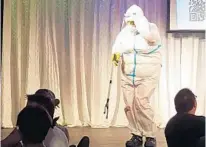  ?? MATTHEW J. PALM/ORLANDO SENTINEL ?? A performer in Sunday’s “April Fresh’s Comedy Brunch” at Parliament House’s Footlight Theatre wears an overly protective suit and uses a grabber to collect tips in a playful nod to COVID-19 precaution­s.