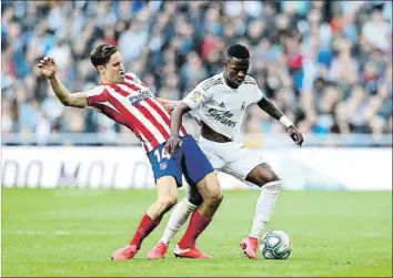  ?? ÁNGEL MARTÍNEZ / GETTY ?? En acció
L’extrem del Madrid Vinícius mirant de superar l’oposició del jugador de l’Atlètic Marcos Llorente, ahir al Santiago Bernabeu