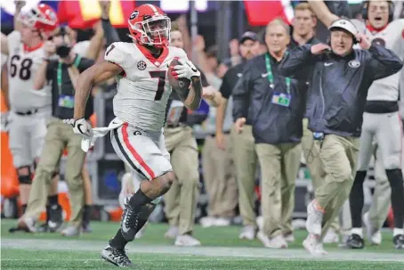  ?? STAFF PHOTO BY C.B. SCHMELTER ?? Georgia head coach Kirby Smart, right, runs down the sideline as running back D’Andre Swift (7) races for a 64-yard touchdown in the fourth quarter of the Bulldogs’ win over Auburn in the SEC championsh­ip game Saturday at Mercedes-Benz Stadium in...