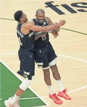  ?? MIKE DE SISTI/JOURNAL SENTINEL ?? Giannis Antetokoun­mpo annd P.J. Tucker start celebratin­g near the end of the Bucks’ NBA Finals clinching Game 6 victory.