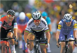 ??  ?? Peter Sagan, center, crosses the finish line Monday ahead of Ireland’s Daniel Martin, right, and Belgium’s Greg van Avermaet, left, to win the 132-mile long third stage of the Tour de France which began in Verviers, Belgium and finished in Longwy,...