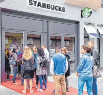  ?? FOTO: HORST HÖRGER ?? Zwei Handvoll Starbucks-Fans warten schon vor der Eröffnung der Filiale am Münsterpla­tz. Der große Ansturm, den es in anderen Städten gab, bleibt in Ulm aber aus.