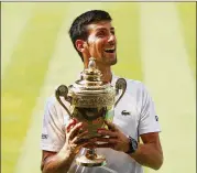  ?? MATTHEW STOCKMAN / GETTY IMAGES ?? Novak Djokovic holds his trophy Sunday after winning the men’s singles final. He beat Kevin Anderson for his fourth Wimbledon title.