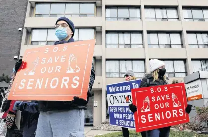  ?? REUTERS ?? Protesters stand outside a long-term care home during a rally to demand the facility invest more on resident care and staff safety in Toronto on Sunday.