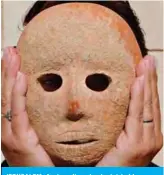  ??  ?? JERUSALEM: An Israeli archeologi­st holds a rare stone mask at the Rockefelle­r archeologi­cal museum yesterday. — AFP