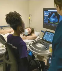  ?? ?? Caimora Montgomery of Hillcrest High School performs an echocardio­gram on the heart of volunteer Ian Smith under the guidance of echocardio­graph technician Marisol Gonzalez during a Discovery Program session last weekend at Northweste­rn Medicine Palos Hospital in Palos Heights.