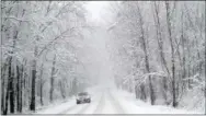  ?? BEN GARVER — THE BERKSHIRE EAGLE (VIA AP) ?? A car drives on a snowy road in Pittsfield, Mass., on Friday.