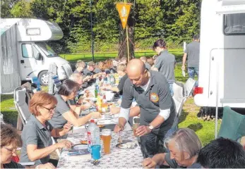  ?? FOTO: FLORIAN HAAG ?? An einer langen Tafel und unter ihrer Fahne ließen es sich die Ehinger Camper in Lindau zum Saisonende gut gehen.