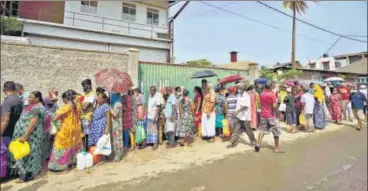  ?? REUTERS ?? Sri Lankans wait in a queue to buy kerosene oil for cooking outside a fuel station in Colombo.