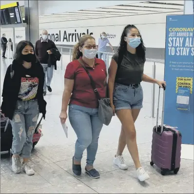  ??  ?? HEADING INTO SELF-ISOLATION: Passengers on a flight from Madrid arrive at Heathrow Airport yesterday following the sudden rule change.