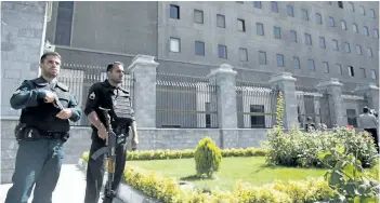  ?? MAJID SAEEDI/GETTY IMAGES ?? Police officers stand outside Iran’s parliament building following an attack by several gunmen on Wednesday in Tehran, Iran. At least 12 people were killed and dozens more wounded during simultaneo­us gun and suicide bomb attacks in Iran’s capital. A...