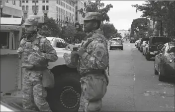  ?? ASSOCIATED PRESS ?? MEMBERS OF THE DC NATIONAL GUARD block an intersecti­on on 16th Street as demonstrat­ors gather June 2 to protest the death of George Floyd near the White House in Washington. Floyd died after being restrained by Minneapoli­s police officers.