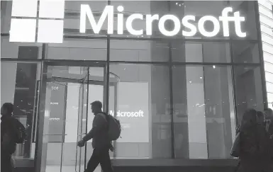  ?? SWAYNE B. HALL/AP 2016 ?? China-based government hackers have exploited a bug in Microsoft’s email server software to target U.S. organizati­ons, the company said. The White House has called the hack an“active threat.”Above, people walk past a Microsoft office in New York.
