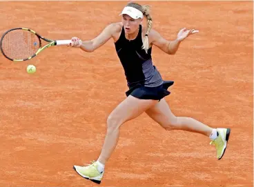  ??  ?? Caroline Wozniacki of Denmark returns a shot against Pauline Parmentier of France during their third round match of the French Open at the Roland Garros stadium in Paris, France, on Friday. Wozniacki won 6-0, 6-3. —