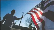  ?? NEWS-SENTINEL FILE PHOTOGRAPH ?? More than 30 spectators hold flags on Beckman Lane on Oct. 31, 2009, as they wait for a procession carrying the casket of U.S. Army Spc. Kyle Coumas who was killed in action on Oct. 21, 2009, in Afghanista­n.