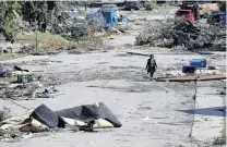  ?? PHOTO: REUTERS ?? Blasted . . . A woman walks past debris after a tornado hit the MontBleu neighbourh­ood in Gatineau, Quebec, Canada, on Saturday.