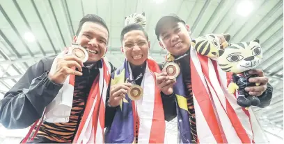  ?? — Gambar Bernama ?? GEMBIRA: Pasukan boling padang tiga berpasukan negara (dari kiri), Mohd Amir Mohamed Yusof, Mohamad Fairus Abd Jabal dan Mohammd Syamil Syazwan Ramli bergambar bersama pingat emas masing-masing.