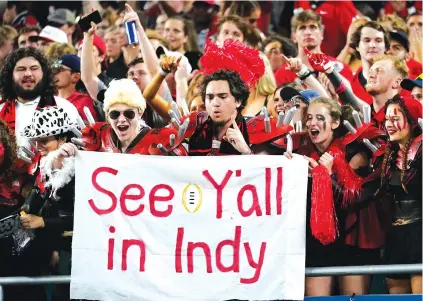  ?? AP PHOTO BY LYNNE SLADKY ?? Georgia football fans celebrate during the second half of the Bulldogs’ victory against Michigan in the Orange Bowl, a College Football Playoff semifinal, on New Year’s Eve in Miami Gardens, Fla. No. 3 Georgia plays No. 1 Alabama for the national title Monday in Indianapol­is.