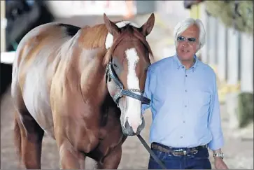  ?? Julio Cortez Associated Press ?? BOB BAFFERT WALKS JUSTIFY around Belmont Park in June, before the colt became the 13th winner of the Triple Crown. The trainer thinks the 1 1⁄2-mile race might have been a factor in the horse’s injury.