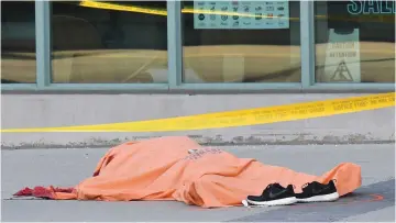  ?? (Reuters) ?? A COVERED BODY lies on a sidewalk after a van struck people in Toronto on Monday.