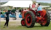  ?? JONATHAN TRESSLER — THE NEWS-HERALD ?? Jessica Madden, left, snags a snapshot of her daughters, from left: 9-year-old Gabby; Claire, 6, and Grace, 12, on one of the tractors on display at Lake Metroparks Farmpark during the Apple Butter &amp; Cider Festival there Sept. 22.