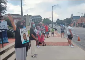  ??  ?? Protesters raise their hands up in solidarity as they listen to Rev. Carey Ingram sing “We Shall Overcome” at the We Matter protest on Sunday.