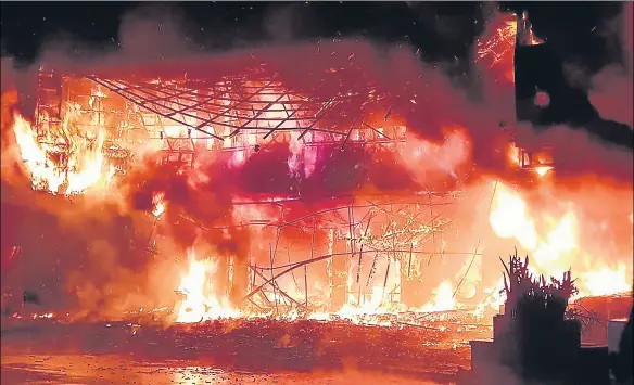  ?? AFP ?? A photo released by Kaohsiung’s fire department shows firefighte­rs battling a blaze that tore through a building in the southern Taiwanese city.