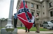  ?? Rory Doyle, Afp/getty Images ?? Officials conduct a flag retirement ceremony July 1 at the Mississipp­i Capitol in Jackson. The last U.S. state flag to feature a Confederat­e emblem was permanentl­y retired and removed from the grounds.