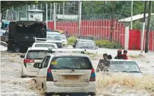  ?? AFP ?? Vehicles drive along a flooded road after heavy rainfall in Srinagar yesterday. Authoritie­s issued a flood alert in central Kashmir as intermitte­nt rain continues.