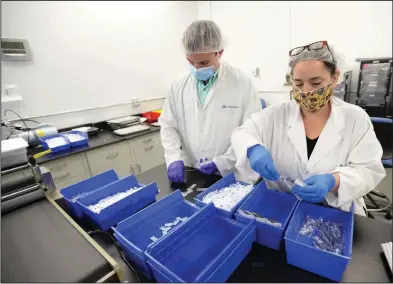  ??  ?? Mason Blaschke, (left) and Gabriella Miller work together Thursday assembling covid-19 antibody tests at NOWDiagnos­tics in Springdale. Visit nwaonline.com/200614Dail­y/ for today’s photo gallery.