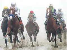  ??  ?? Justify (second left) ridden by jockey Mike Smith leads the field in the first pass the 143rd running of the Preakness Stakes at Pimlico Race Course in Baltimore. — AFP photo