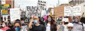  ??  ?? Protesters hold up various signs during a protest on 26th St. in Little Village.